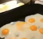 guy coughing while cooking eggs